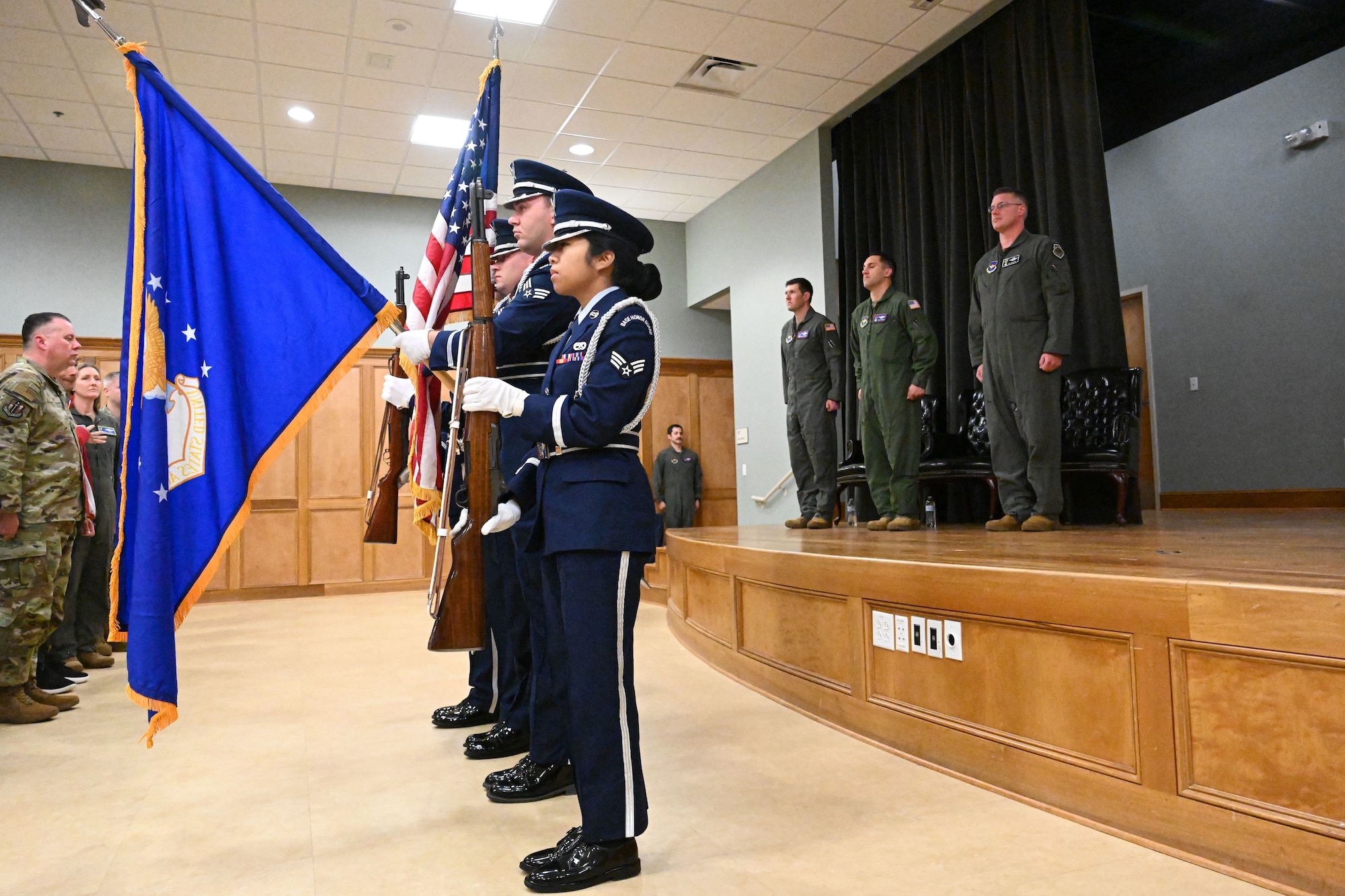 Men and women in uniform present colors.