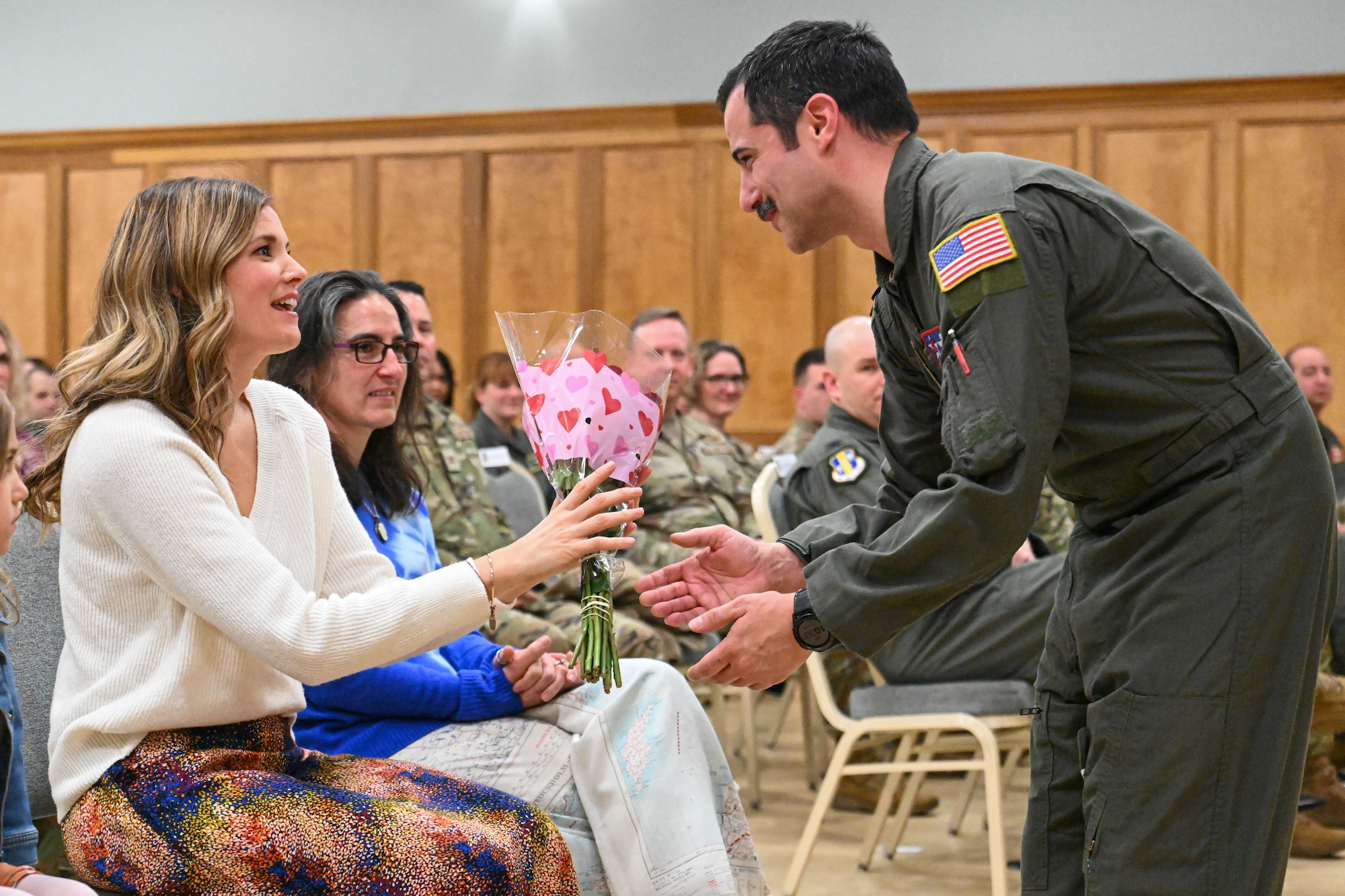 Men in uniform gives flowers to incoming commander's wife.