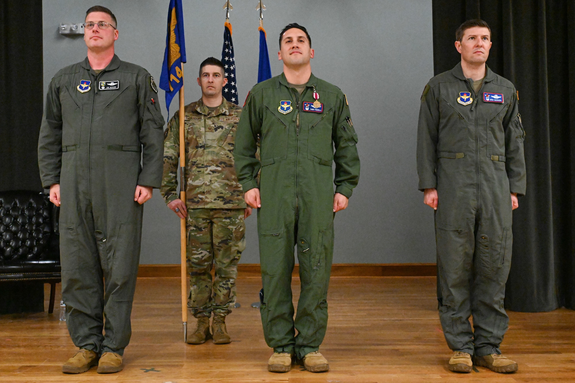 Men in uniform stand at attention.