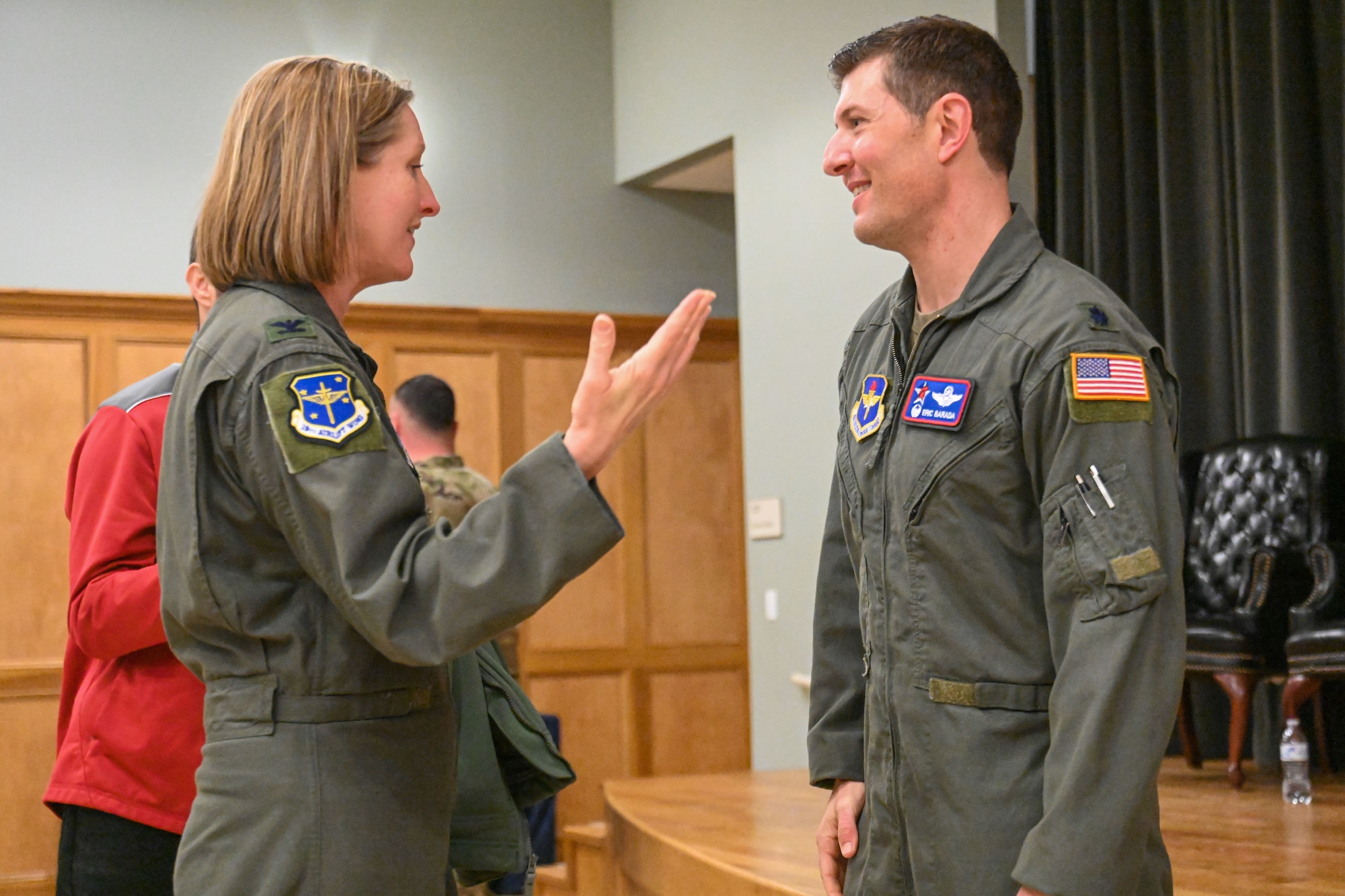 Man in uniform is congratulated by base commander.