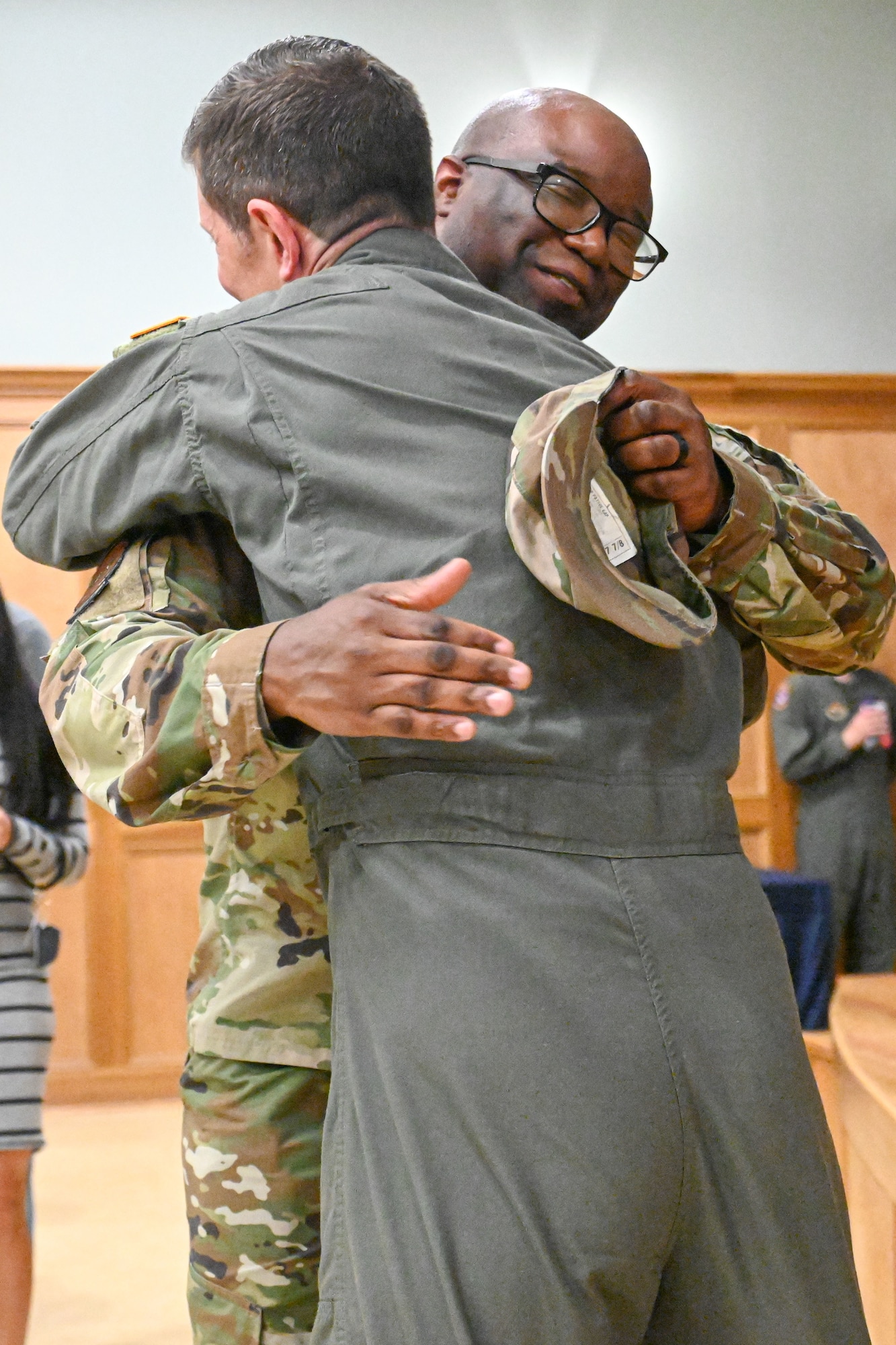 Man in uniform in congratulated with a hug.