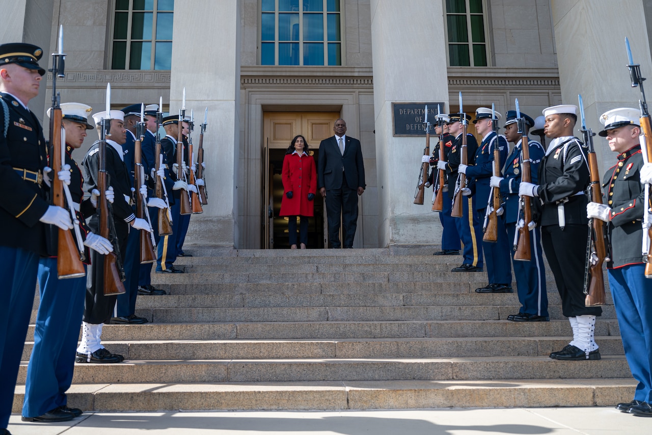 A man and woman stand next to each other at the top of steps.