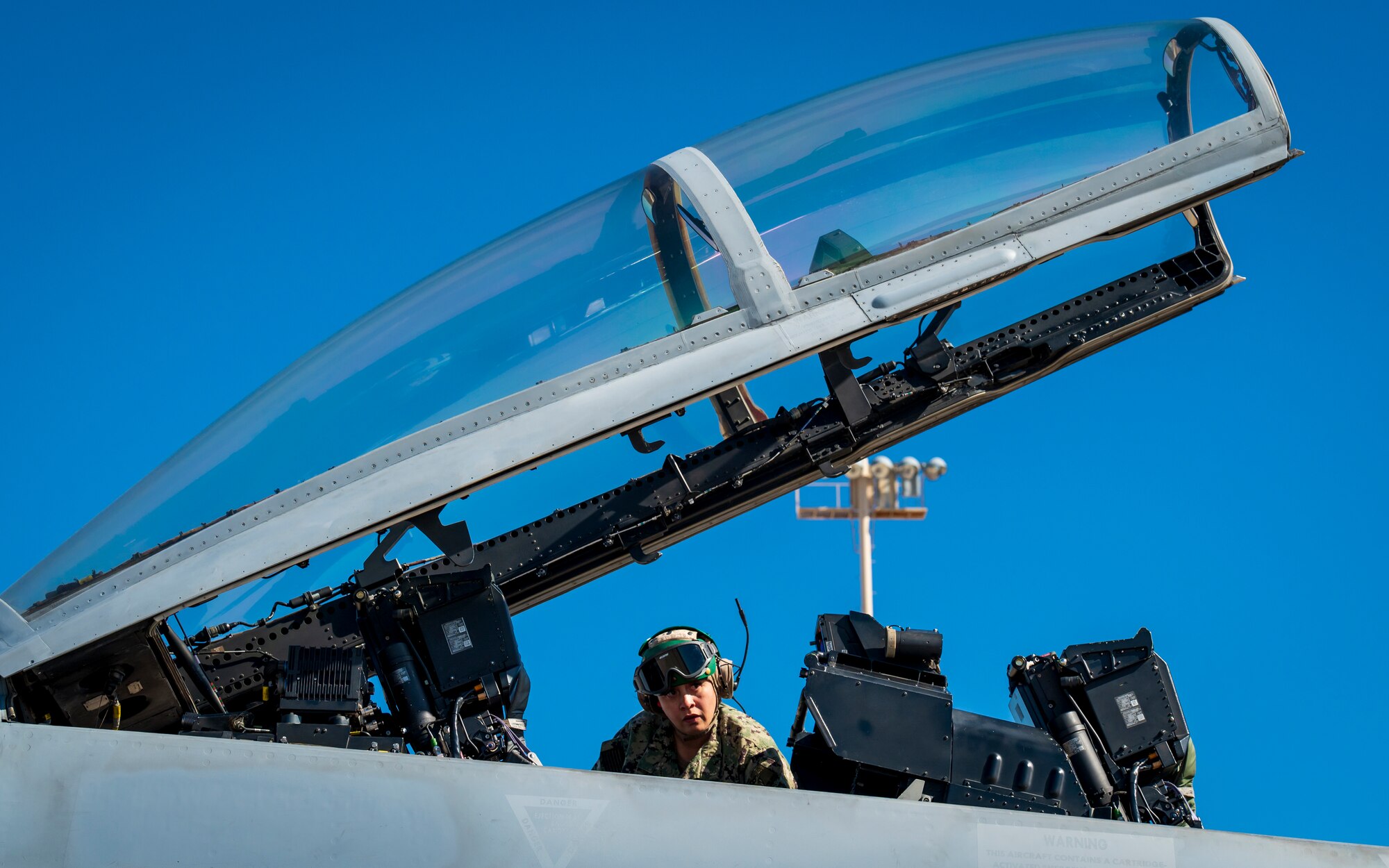 U.S. Navy AME3 Ariana Scott conducts checks inside the cockpit of an F/A-18E Super Hornet assigned to the “Flying Eagles” of Strike Fighter Squadron (VFA) 122, Lemoore, California, at Luke Air Force Base, Arizona, Feb. 7, 2023.