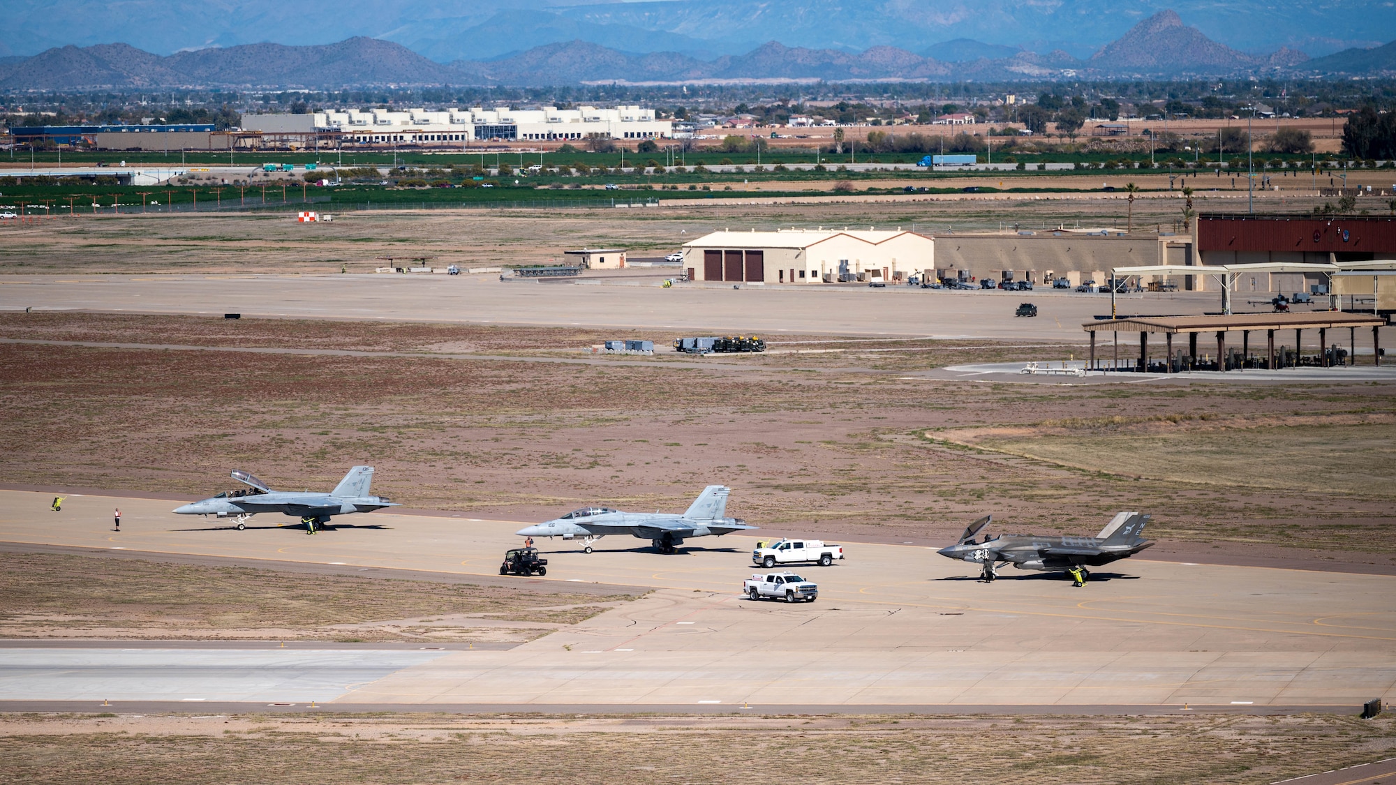 Two U.S. Navy F/A-18F Super Hornets assigned to the “Flying Eagles” Strike Fighter Squadron (VFA) 122 and an F-35C Lightning II assigned to the "Warhawks" Strike Fighter Squadron (VFA) 97 out of Naval Air Station (NAS) Lemoore, California, sits on the flightline at Luke Air Force Base, Arizona, Feb. 7, 2023.