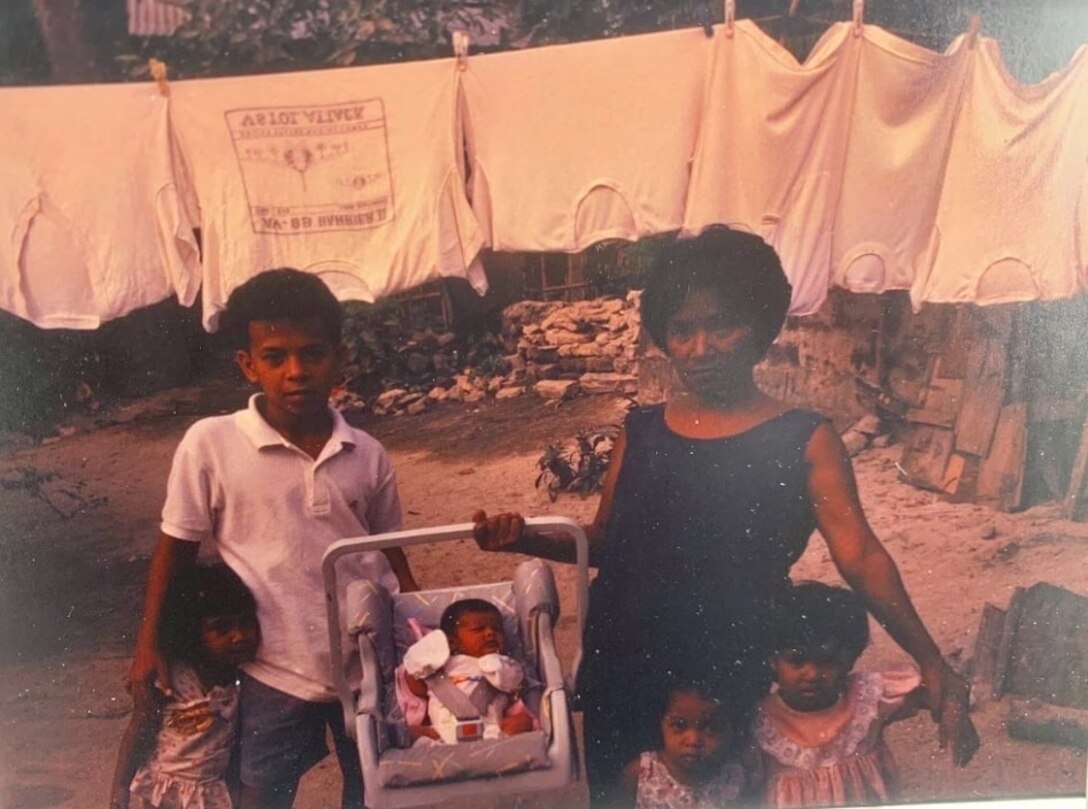 Sgt. 1st Class Christian Araza, in his childhood, stands with his extended family and his grandmother, Julie Flores, near Subic Bay, Philippines. Araza was raised in the Philippines from birth until the age of sixteen and was able to visit his family for the first time in seven years during his employment in the Indo-Pacific.