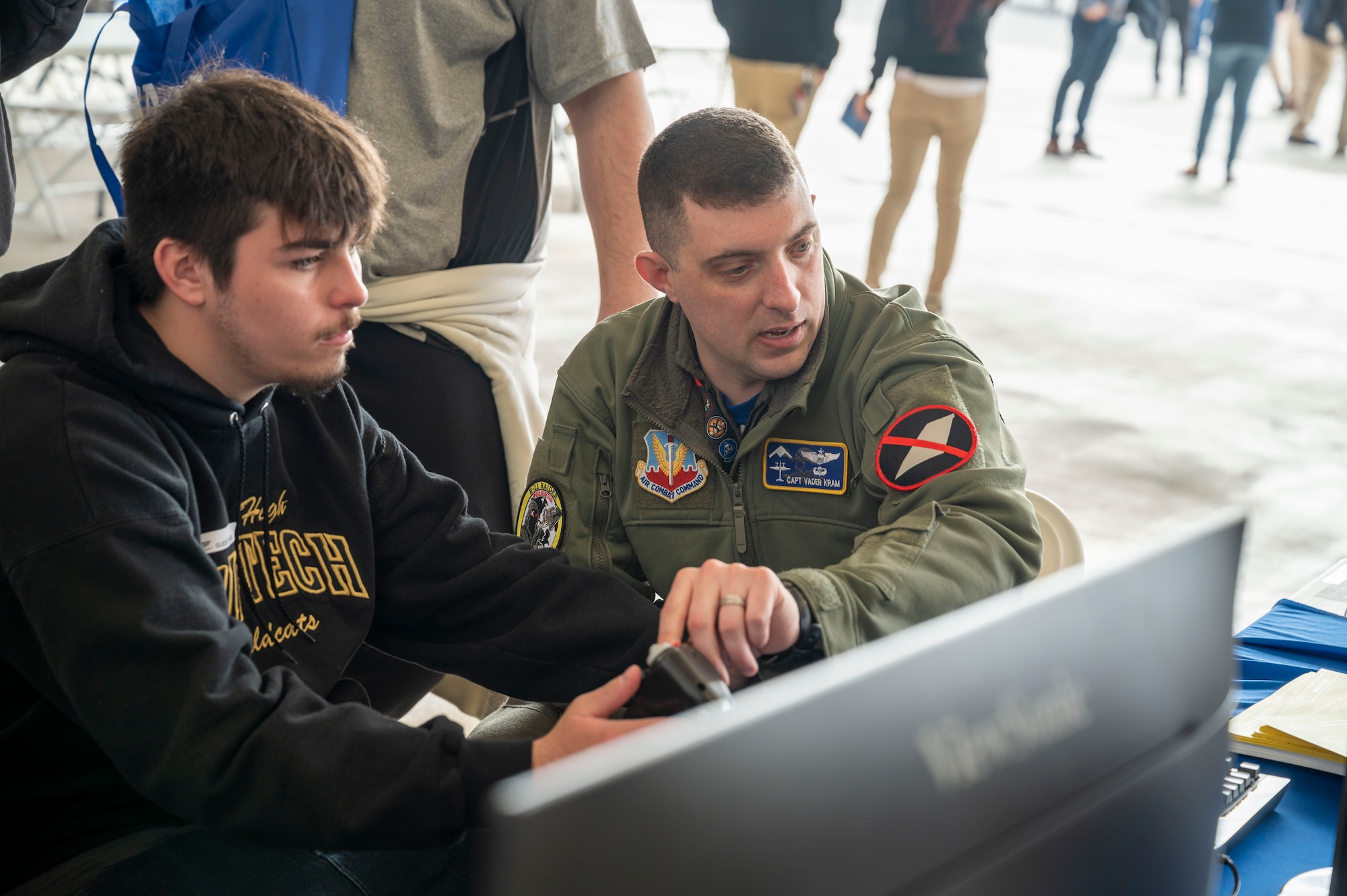 Capt. Benjamin "Vader" Kram, 31st Test and Evaluation Squadron teaches a student about how to use the flight simulator at California Aeronautical University Aviation Career Day in Bakersfield, California, Feb. 3.
