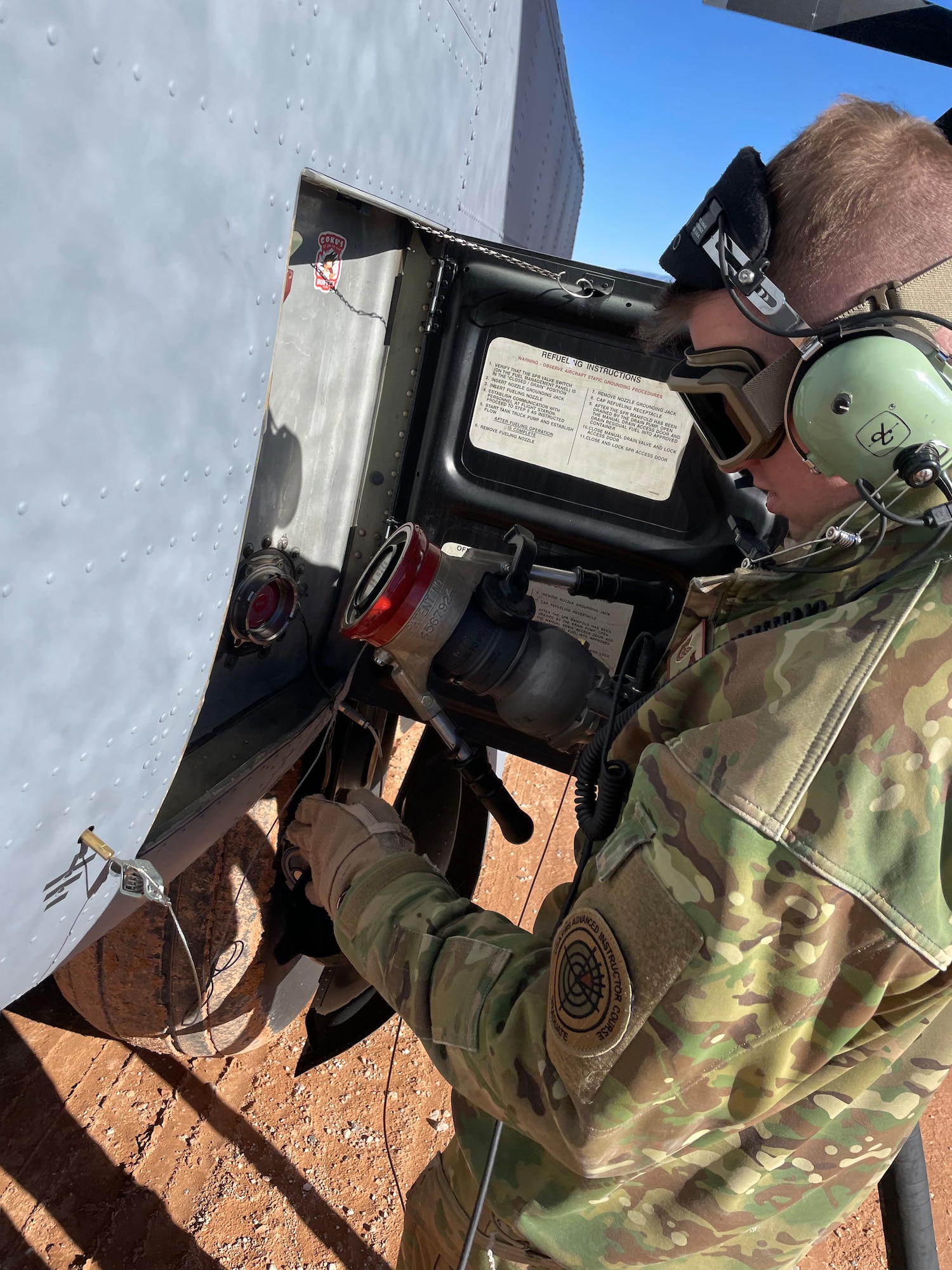 U.S. Air Force Tech. Sgt. Christopher Hofer, 40th Airlift Squadron operations flight chief, connects a fuel hose to a C-130J Super Hercules at Fort Bliss, Texas, Jan. 25, 2023. The 317th Airlift Wing executed an Agile Combat Employment exercise by sending a C-130 to the Fort Bliss Range to perform Specialized Fueling Operations with the 3rd Brigade Combat Team, 1st Armored Division and the 1st Battalion, 77th Armored Regiment. The units successfully passed fuel from a C-130 to an M1A2 Abrams Tank utilizing an Emergency Response Refueling Equipment Kit, marking the first time in Air Force history that a C-130 has been used to refuel an Abrams tank. (Courtesy photo)