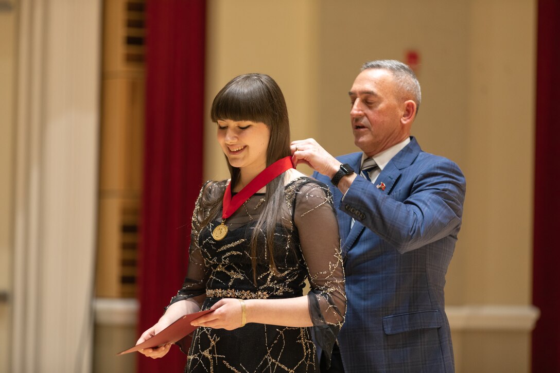 MajGen James W. Lukeman USMC (Ret), president and CEO of the Marine Corps Heritage Foundation, awards Flutist Nikka Gershman third place in the 2023 Marine Band Concerto Competition.