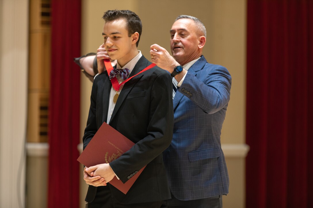MajGen James W. Lukeman USMC (Ret), president and CEO of the Marine Corps Heritage Foundation, awards Bassoonist Nathan Shepherd second place in the 2023 Marine Band Concerto Competition.