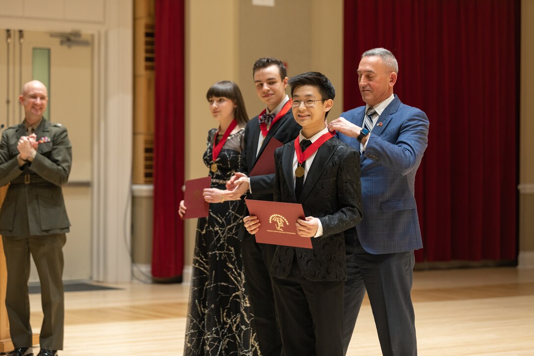 MajGen James W. Lukeman USMC (Ret), president and CEO of the Marine Corps Heritage Foundation, awards Oboist Kyle Cho first place in the 2023 Marine Band Concerto Competition.