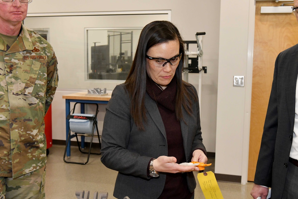 Photo shows woman looking at a part in her hands