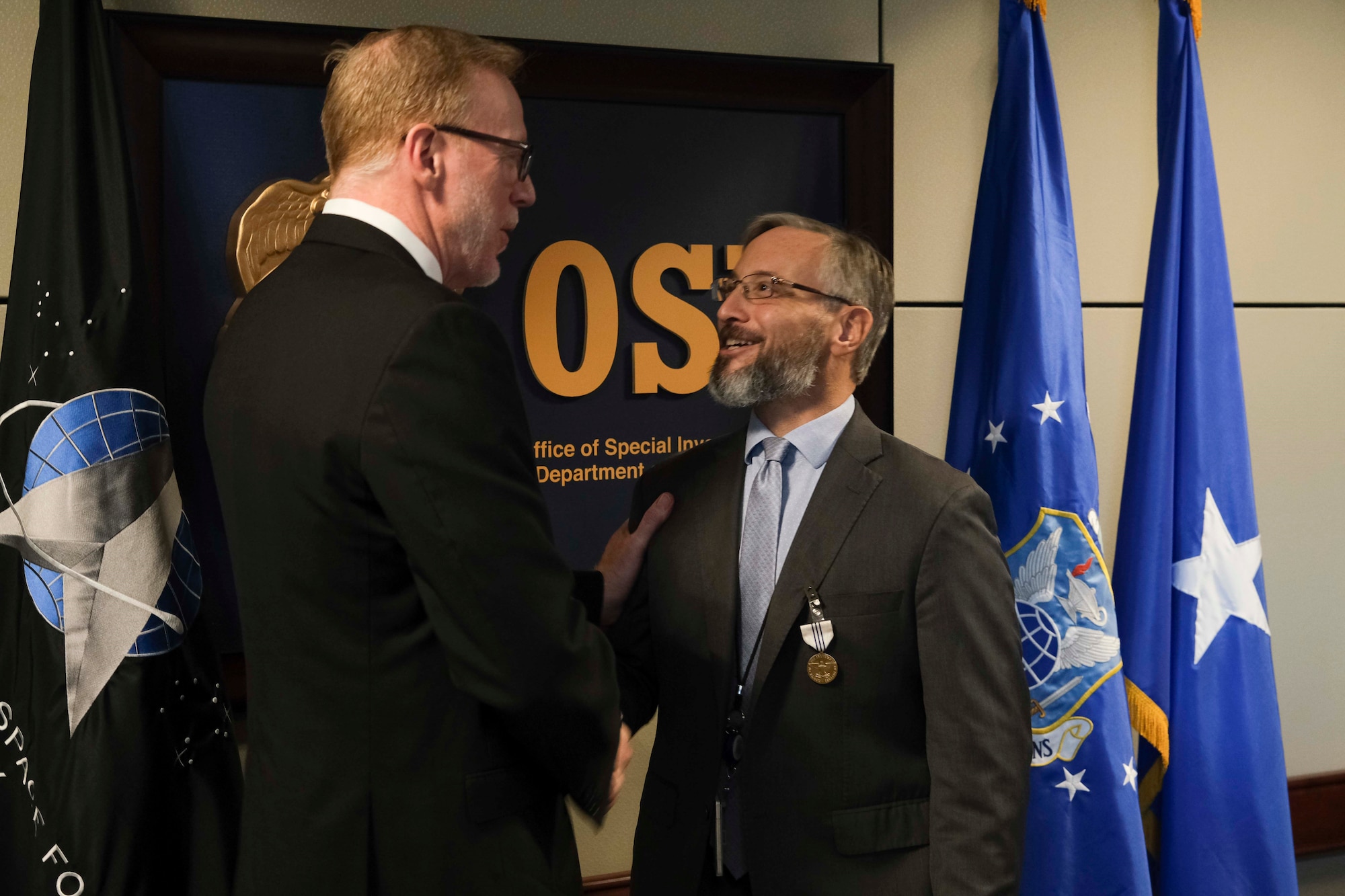 SA James Cangialosi is congratulated by Mr. John Dixson, acting Director for Defense Intelligence Counterintelligence, Law Enforcement & Security, after receiving The Office of the Secretary of Defense Medal for Exceptional Civilian Service at the Russell-Knox Building, Jan. 27, 2023. Cangialosi received the award for his work with the defense intelligence community. (U.S. Air Force photo by Tech. Sgt. Joshua King, OSI/PA)