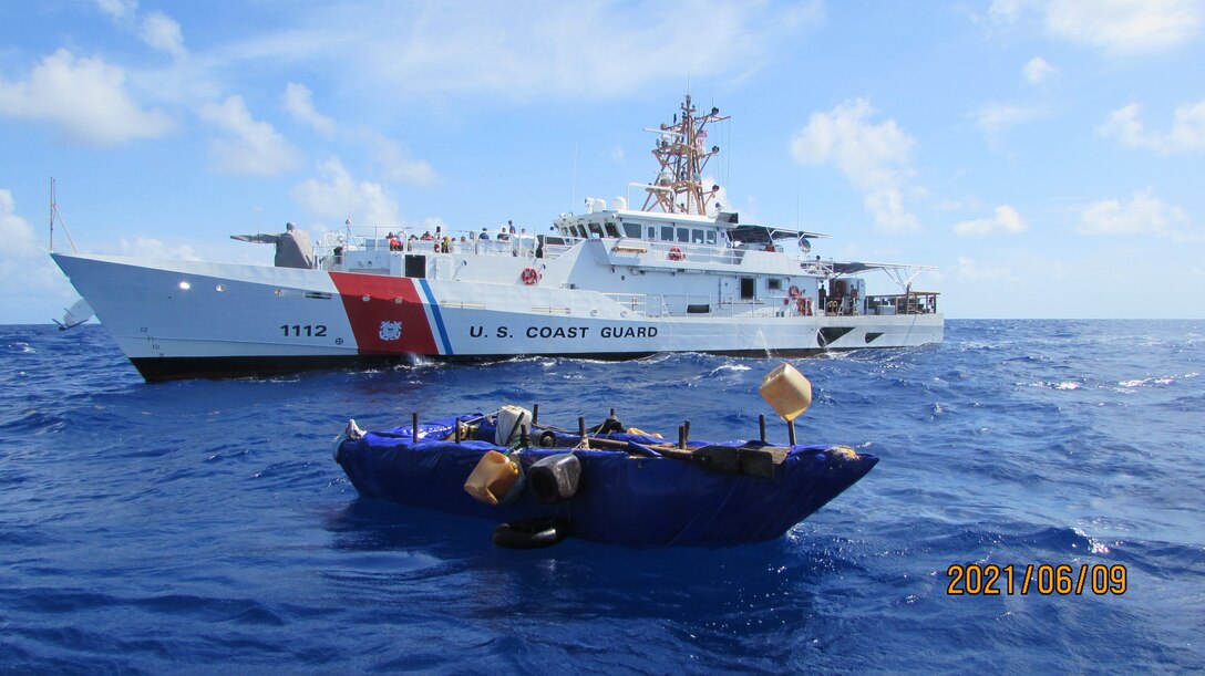 An unseaworthy migrant craft sits in front of the Coast Guard Cutter Isaac Mayo, 27 miles south of Long Key, Florida, June 9, 2021. A law enforcement team from the cutter interdicted 16 Cuban migrants from the craft. (U.S. Coast Guard photo)