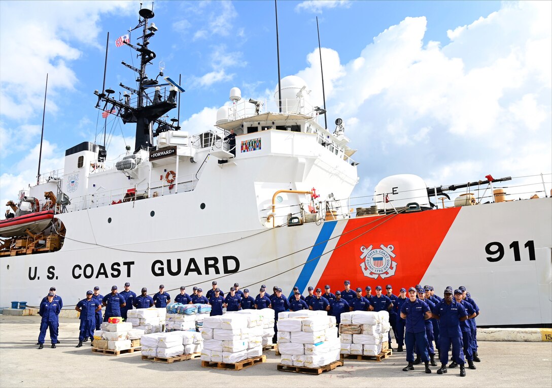 The crew of the Coast Guard Cutter Forward pose with approximately 13,375 pounds of cocaine in Port Everglades, Florida, Dec. 15, 2022.