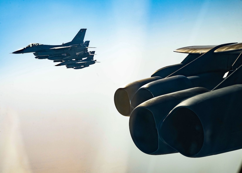 Fighter jets and a bomber aircraft fly together.