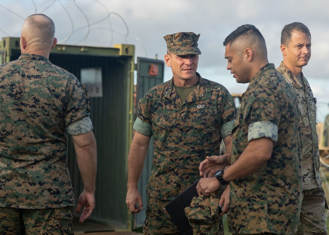 U.S. Marine Corps Brig. Gen. Joseph R. Clearfield, center, deputy commander of U.S. Marine Corps Forces, Pacific, speaks with Lt. Col. Adrian L. Solis, Force Design integration officer, U.S. Marine Corps Forces, Pacific while visiting the site of an expeditionary command and control (C2) node during a training exercise at Camp H.M. Smith, Hawaii, Feb. 7, 2023. Forces from I Marine Expeditionary Force (MEF) and III MEF established a Multi-Function Air Operations Center and Multi-Domain Operations Center during the exercise to synchronize all-domain effects across the Indo-Pacific region for the Joint Force and interagency partners. The C2 node, operated by Marines of MACG-38 and 3rd MAW informed and enabled the synchronization of organic, joint, and/or interagency fires – both lethal and non-lethal – across air, sea, land, space, and cyber to achieve specific, desired effects during the exercise. (U.S. Marine Corps photo by Sgt. Sasha Pierre-Louis)