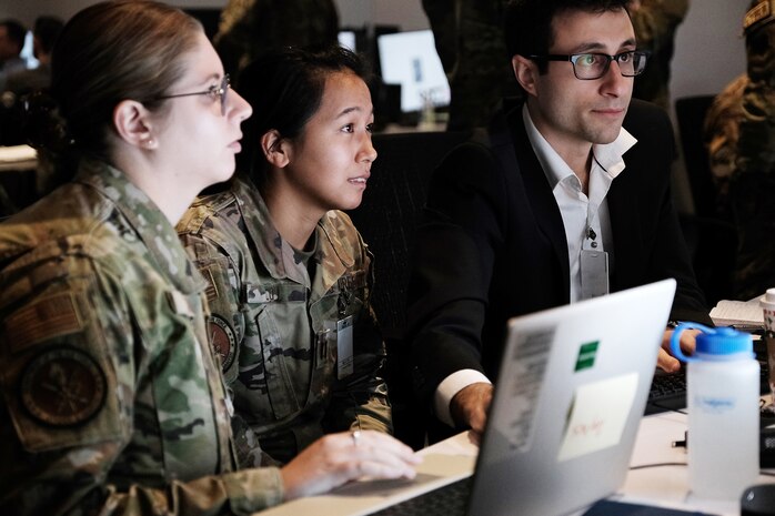 photo of U.S. Air Force military and civilian members working at computers
