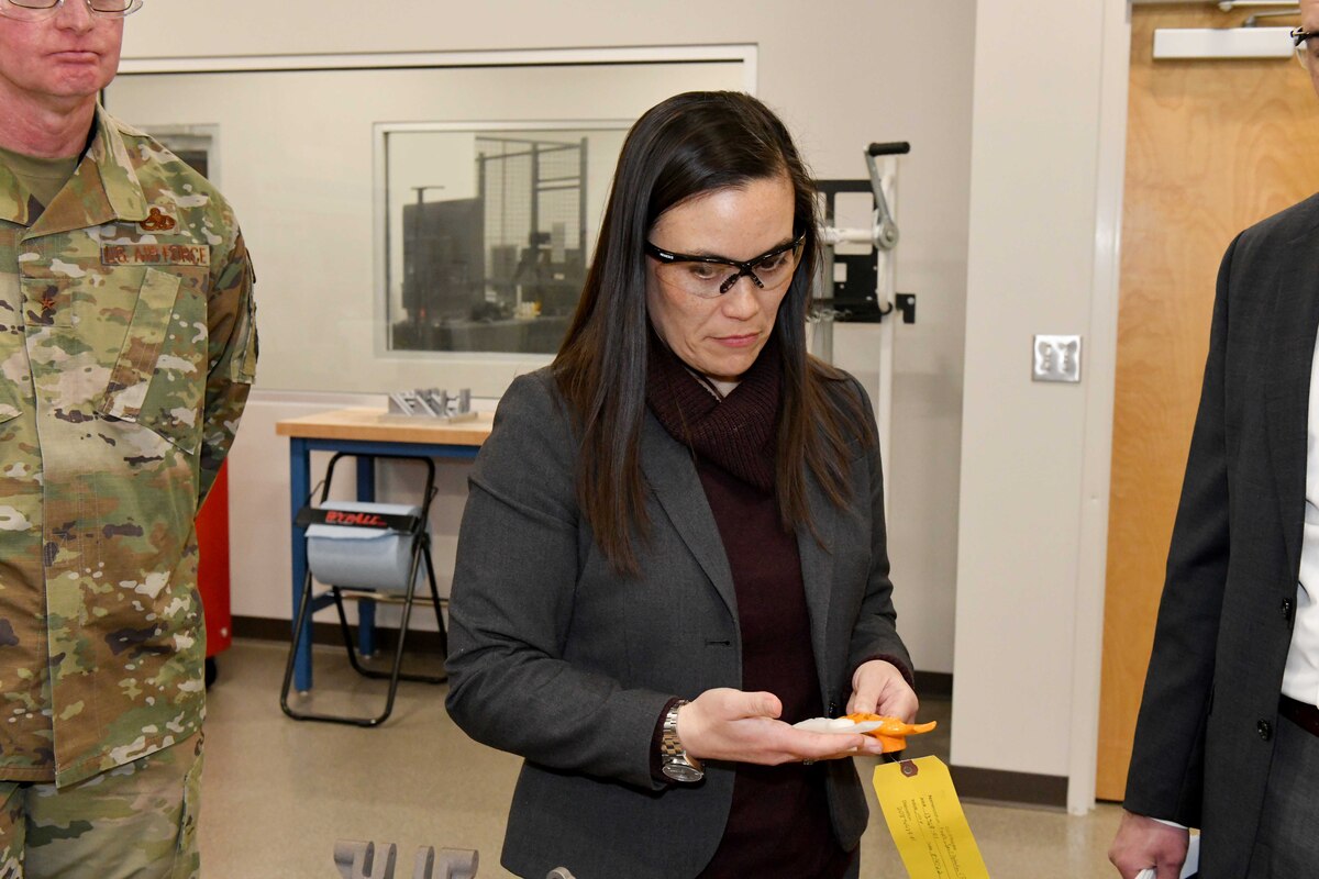 Photo shows woman looking at a part in her hands