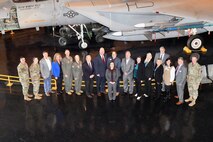Photo shows a large group standing in front of aircraft display