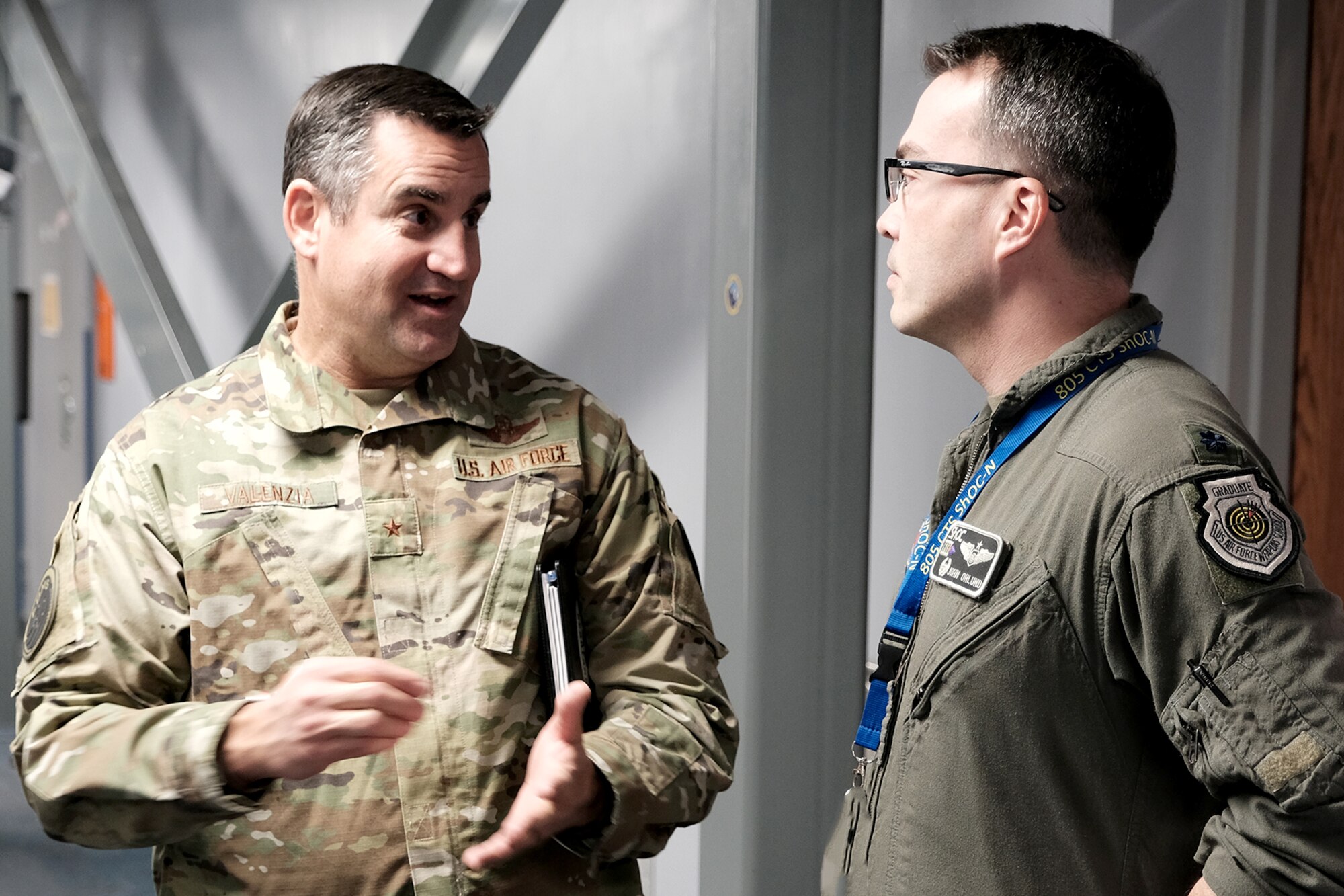photo of U.S. Air Force military member briefs general while others work on computers around them
