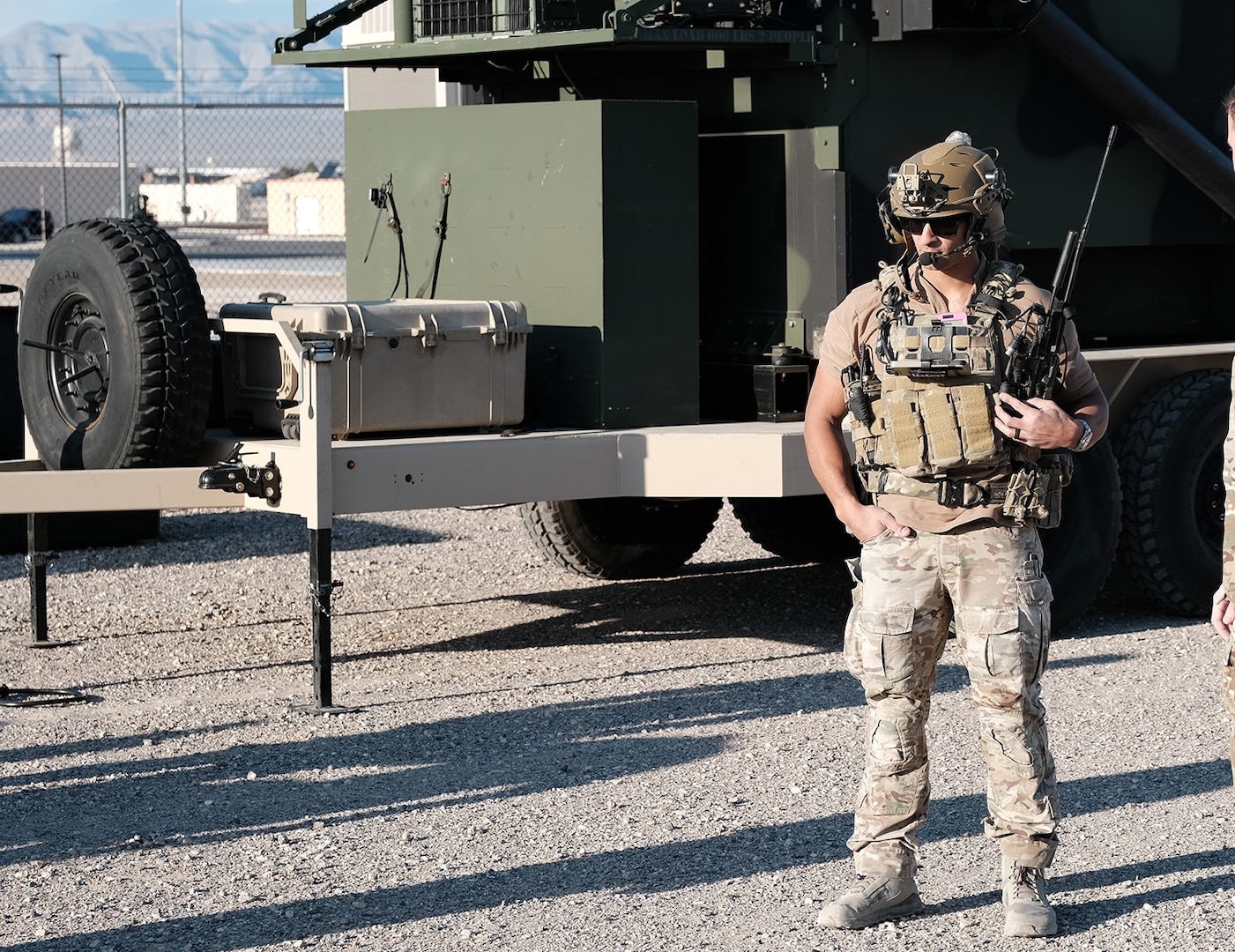 photo U.S. Air Force military member wearing combat gear stands near military vehicles
