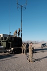 photo of U.S. Air force military members work on top of military vehicles and on the ground