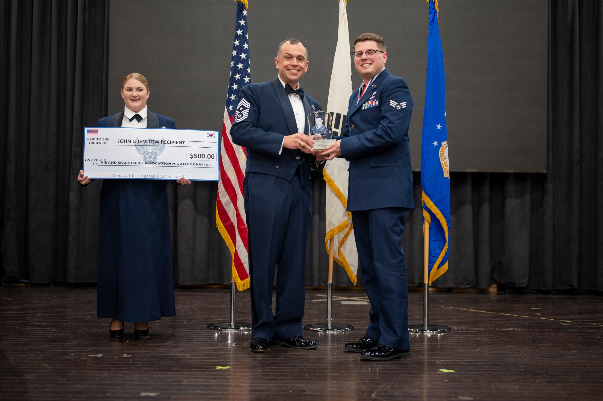 U.S. Air Force Senior Airman Daniel Adams, 731st Air Mobility Squadron, accepts the John Levitow Award from Chief Master Sgt. John Alsvig, 51st Fighter Wing command chief, during the Airman Leadership School graduation ceremony at Osan Air Base, Republic of Korea, Feb. 9, 2023. The Levitow Award is presented to the student that demonstrates the highest standards of leadership and scholastic qualities. Along with the award, Adams was granted five hundred dollars to pursue higher education with. (U.S. Air Force Photo by Airman 1st Class Aaron Edwards)