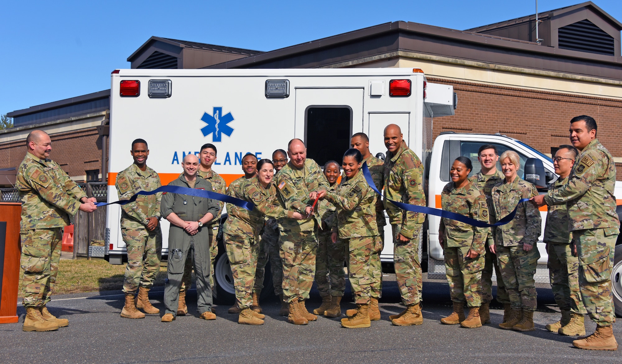 87th MDG and Joint Base MDL leadership pose for a picture while cutting the ALS ceremonial ribbon.