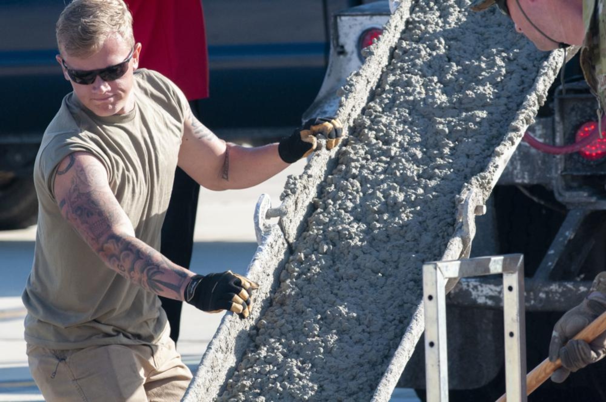 A U.S. Air Force Airman assigned to the 202nd RED HORSE Squadron, Florida Air National Guard, guides a chute as concrete fills a concrete slab on the airfield ramp at Naval Air Station Jacksonville, Florida, Feb. 8, 2023. The 202nd RHS Airmen are rehabbing the airfield to ensure taxiway concrete can withstand the weight of the U.S. Navy's P-8A Poseidon aircraft. (U.S. Air National Guard photo by Tech Sgt. Chelsea Smith)