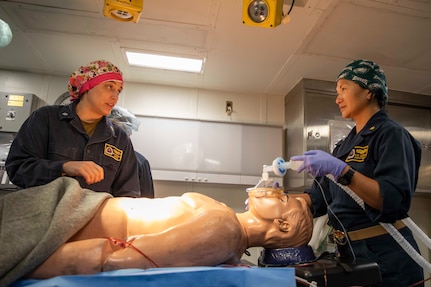 Cmdr. Amy Hernandez, a general surgeon with Fleet Surgical Team (FST) 1, left, and Cmdr. Kim Gerber, a certified registered nurse anesthetist with FST 1, perform a surgery on a mannequin during a casualty response with Sailors from the nuclear aircraft carrier USS Nimitz (CVN 68), aboard amphibious assault ship USS Makin Island (LHD 8), Feb. 11, 2023 in the South China Sea. Nimitz Carrier Strike Group (NIMCSG) and amphibious assault ship USS Makin Island (LHD 8) with embarked 13th Marine Expeditionary Unit are conducting joint expeditionary strike force (ESF) operations, representing unique high-end war fighting capabilities, maritime superiority, and power projection, demonstrating the U.S. commitment to our allies and partners in the Indo-Pacific region. (U.S. Navy photo by Mass Communication Specialist Seaman Joshua Martinez)