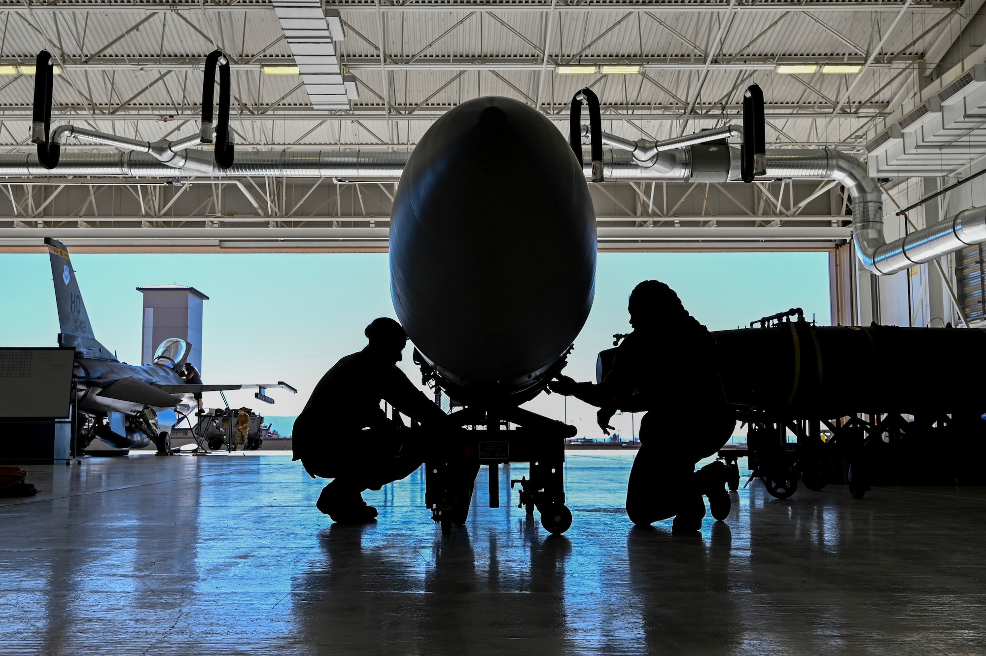 U.S. Air Force Staff Sgt. Thelma Bradshaw, left, and U.S. Air Force Tech. Sgt. Kalani Leetom, 49th Component Maintenance Squadron fuels craftsmen, inspect an F-16 Viper fuel tank at Holloman Air Force Base, New Mexico, Feb. 8, 2023.The 49th CMS fuels shop is in charge of maintaining and supplying anything fuel-related to all F-16 Vipers on base. (U.S. Air Force photo by Airman 1st Class Isaiah Pedrazzini)