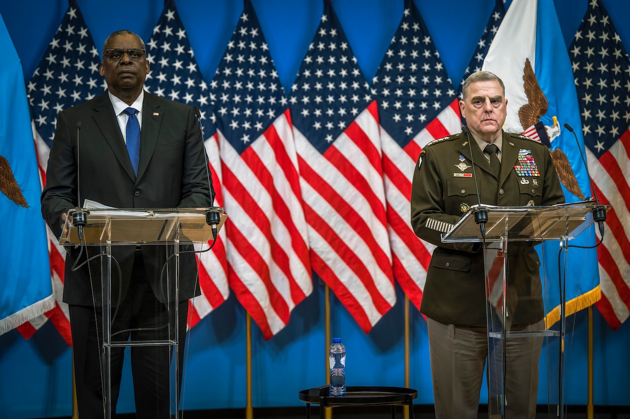 Secretary of Defense Lloyd J. Austin III and Army Gen. Mark A. Milley stand at twin lecterns in front of U.S. flags.