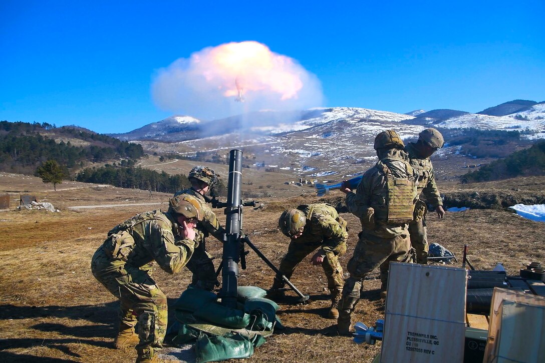 Soldiers fire a mortar system.