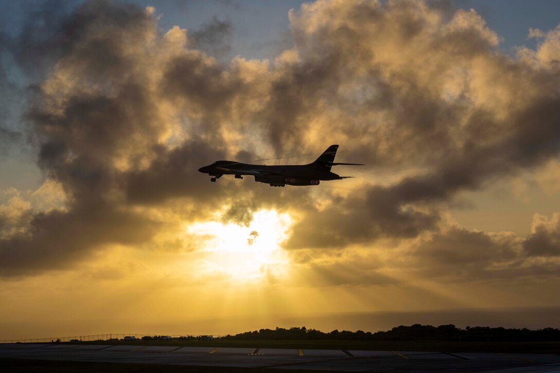 The sun shines through the clouds while an aircraft is midair.