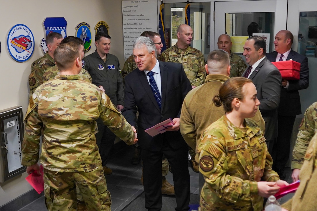 Legislature shakes hand of airman.
