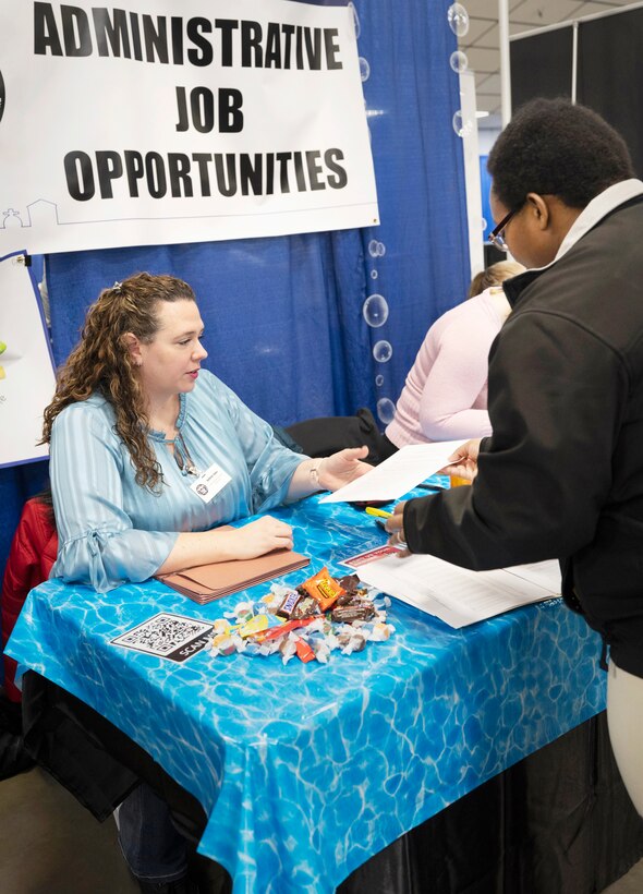 Kathryn Jones, executive assistant, Code 900A, accepts a résumé from a job seeker Feb. 4, 2023, during the Puget Sound Naval Shipyard & Intermediate Maintenance Facility Hiring Fair at the Kitsap County Fairgrounds in Bremerton, Washington. (U.S Navy Photo by Wendy Hallmark)