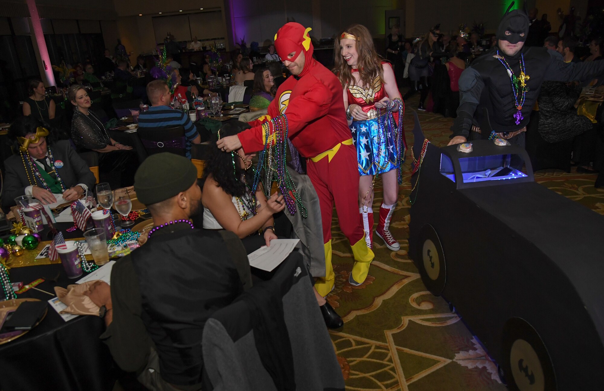 Members of the 81st Operational Medical Readiness Squadron portray DC Comics characters as they make their way down the aisle during the 32nd Annual Krewe of Medics Mardi Gras Ball at the Bay Breeze Event Center on Keesler Air Force Base, Mississippi, Feb. 11, 2023.
