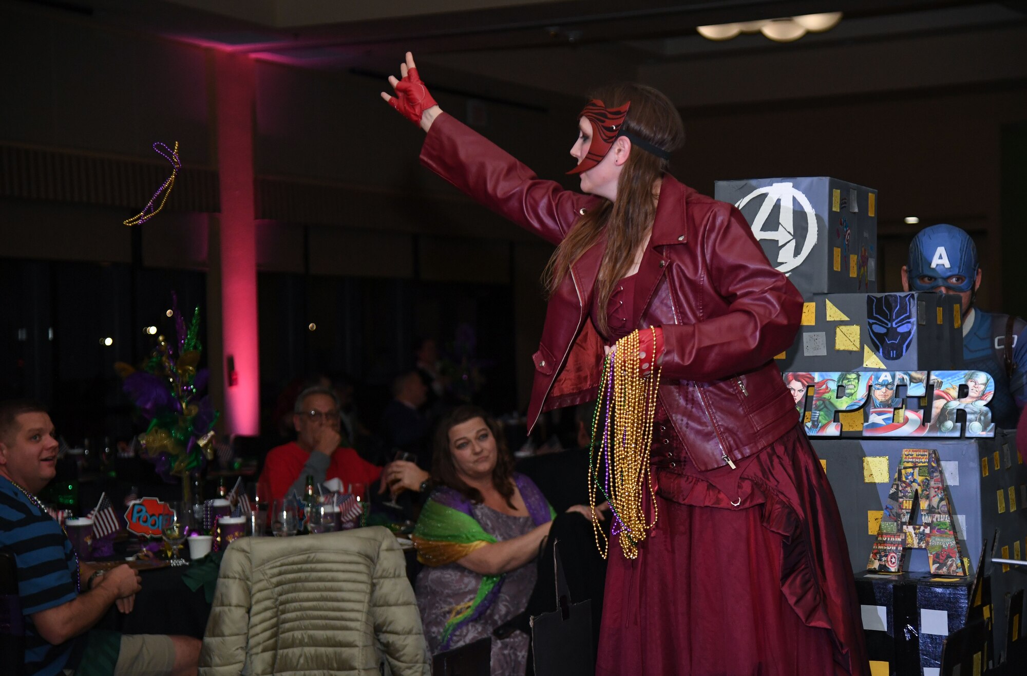 U.S. Air Force Staff Sgt. Kasondra Amacher, 81st Diagnostic and Therapeutics Squadron ultrasound technician, portrays Wanda Maximoff as she tosses beads to the crowd during the 32nd Annual Krewe of Medics Mardi Gras Ball at the Bay Breeze Event Center on Keesler Air Force Base, Mississippi, Feb. 11, 2023.