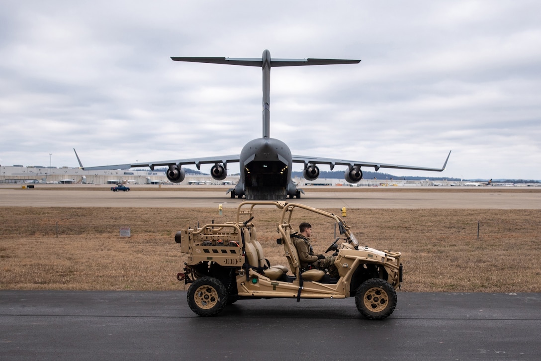 A member of the 123rd Logistics Readiness Squadron prepares to load a vehicle onto a North Carolina Air National Guard C-17 Globemaster III at the Kentucky Air National Guard Base in Louisville, Ky., Feb. 10, 2023. The vehicle is being transported to the Northern Mariana Islands for Cope North, a multinational exercise designed to enhance combat readiness in the South Pacific. Fourteen Kentucky Air Guardsmen from the 123rd Contingency Response Group are providing air base-opening and cargo-handling capabilities for Cope North. (U.S. Air National Guard photo by Phil Speck)