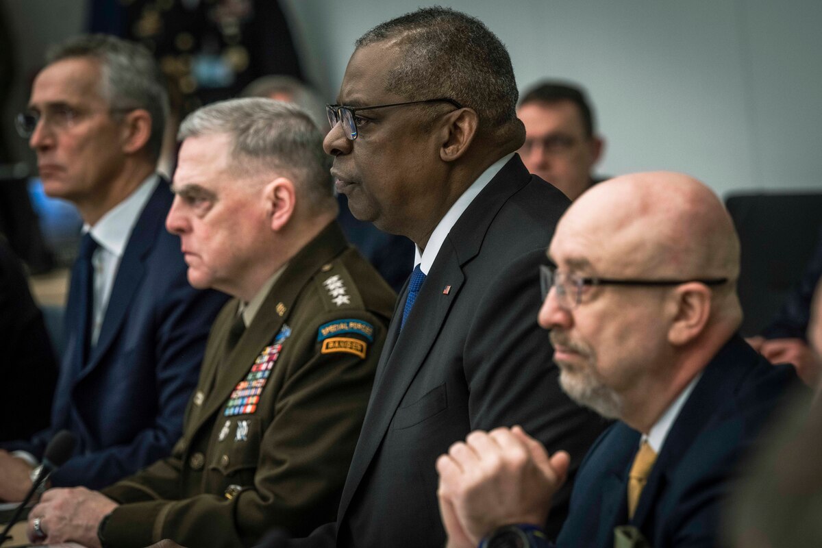 Four men sit at a long table.