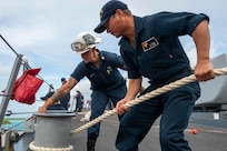 U.S. Navy Seaman Yunpeng Jiang, from Fujian, China, and Boatswain's Mate 1st Class Fawn Savoie, from Houma, La., handle mooring line during sea-and-anchor detail on the foc'scle of the Arleigh Burke-class guided-missile destroyer USS Paul Hamilton (DDG 60) during a routine port visit. Paul Hamilton, part of the Nimitz Carrier Strike Group, is in U.S. 7th Fleet conducting routine operations. 7th Fleet is the U.S. Navy’s largest forward-deployed numbered fleet, and routinely interacts and operates with Allies and partners in preserving a free and open Indo-Pacific region. (U.S. Navy photo by Mass Communication Specialist 2nd Class Elliot Schaudt)