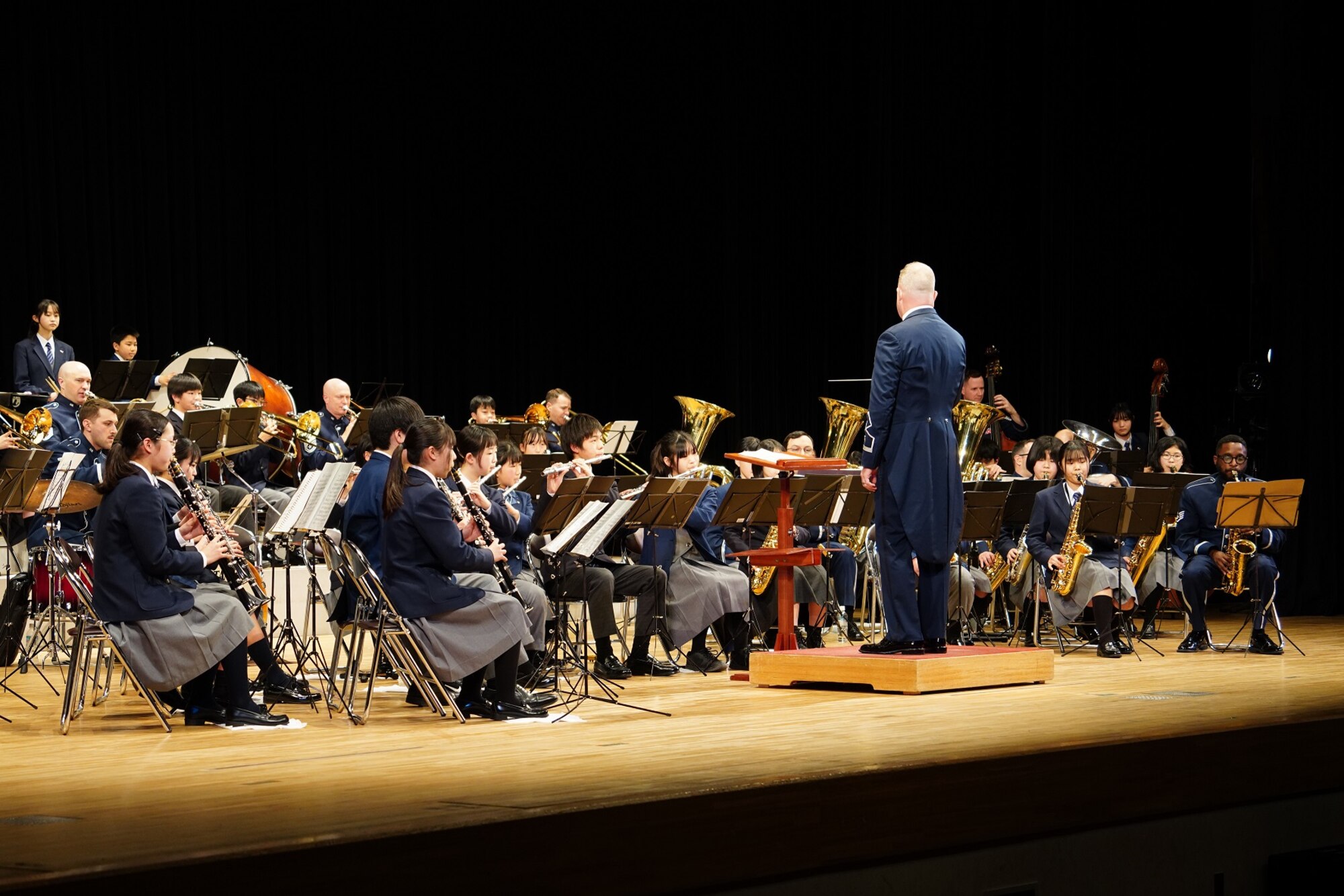Lt. Col. Jason Plosch, U.S. Air Force Band of the Pacific commander, conducts a united band of Air Force musicians and approximately 50 junior high school students from Fussa City during the annual Japan – U.S. Joint Concert at the Fussa Shimin Kaikan Hall, Fussa, Japan, Feb. 11, 2023.
