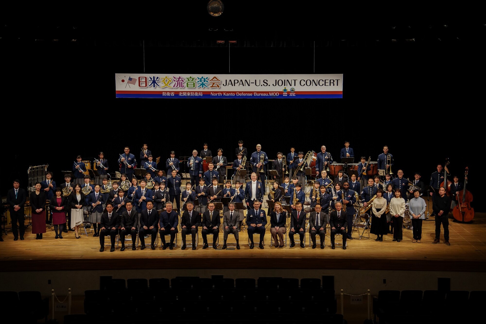 Members of the U.S. Air Force Band of the Pacific pose with Fussa City Junior High School students and teachers, along with leaders from Yokota Air Base, Fussa City, and the North Kanto Defense Bureau, for a photo after the annual Japan – U.S. Joint Concert at the Fussa Shimin Kaikan Hall, Fussa, Japan, Feb. 11, 2023.