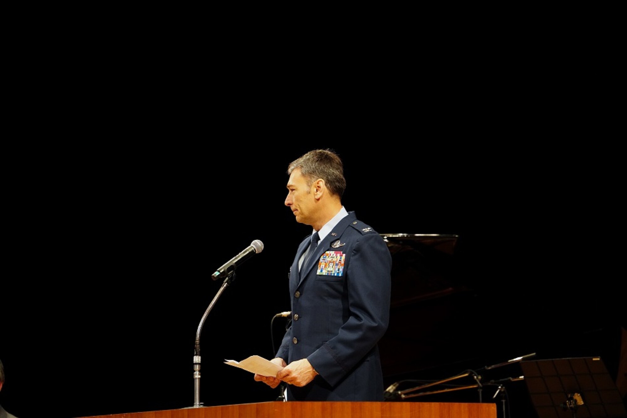 Col. Andrew Roddan, 374th Airlift Wing commander, speaks to concert musicians and attendees of the the annual Japan – U.S. Joint Concert at the Fussa Shimin Kaikan Hall, Fussa, Japan, about the partnership and cooperation between Yokota Air Base and the local community, Feb. 11, 2023.