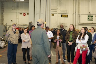 Capt. Patrick Baker, Executive Officer of the Nimitz-class aircraft carrier USS Abraham Lincoln (CVN 72) speaks to Navy Office of Legislative Affairs (OLA) liaisons in the hangar bay aboard USS Abraham Lincoln. Navy OLA’s case workshop helps congressional caseworkers gain a greater understanding of Navy facilities, operations, and perspectives, and provide caseworkers the opportunity to tour ships, squadrons, or facilities; meet Sailors and leadership; and discuss various topics that affect constituent casework. (U.S. Navy photo by Mass Communication Specialist 3rd Class Michael J. Cintron)