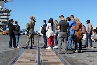 Senior Chief Mass Communications Specialist Justin Webb from Enola, Ark. speaks to Navy Office of Legislative Affairs (OLA) liaisons on the flight deck aboard USS Abraham Lincoln. Navy OLA’s case workshop helps congressional caseworkers gain a greater understanding of Navy facilities, operations, and perspectives, and provide caseworkers the opportunity to tour ships, squadrons, or facilities; meet Sailors and leadership; and discuss various topics that affect constituent casework. (U.S. Navy photo by Mass Communication Specialist 3rd Class Michael J. Cintron)