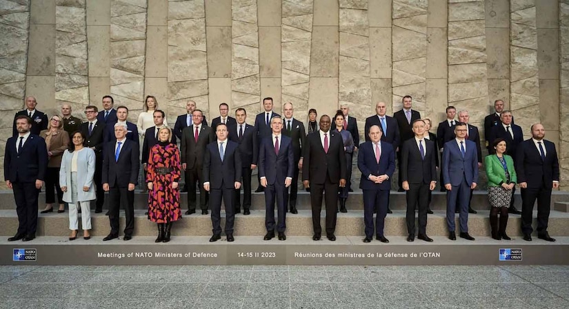 A group of men and women pose for photo.