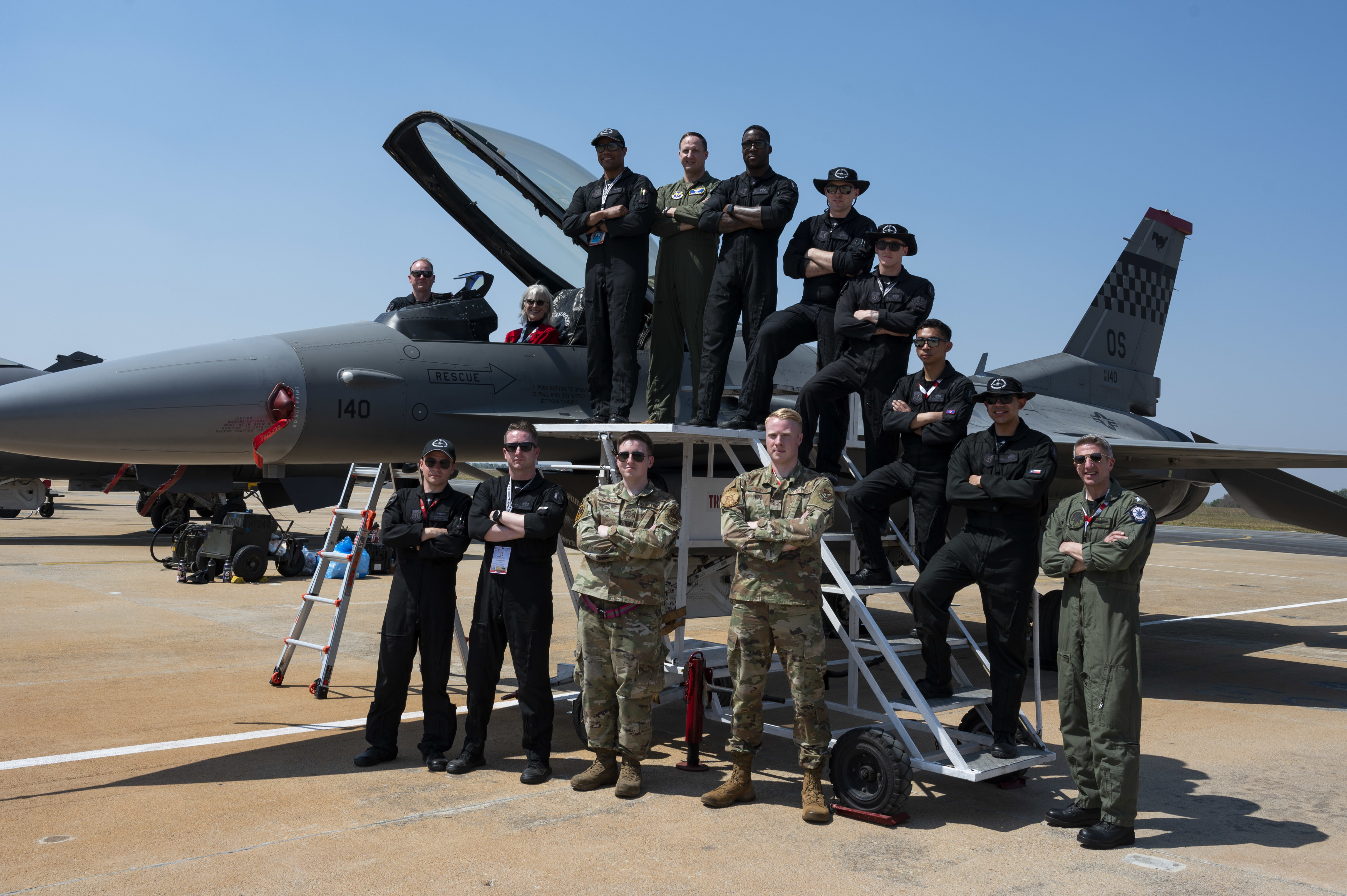 U.S. officials take a group photo with members of the Pacific Air Forces F-16 Demonstration Team during Aero India 23 at Yelahanka Air Station, Bengaluru, India on Feb. 13, 2023. Aero India serves as a venue to showcase American aerospace technology, innovation and defense capability. (U.S. Air Force Photo by Airman 1st Class Emily Saxton)