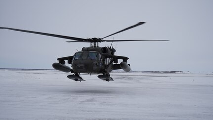 An Alaska Army National Guard UH-60L Black Hawk helicopter hovers near the aviation facility at the Bethel Airport after returning from a training flight. The helicopter is stationed in Bethel for the time being to allow aircrews to train for federal mission requirements and become more familiar with the area.