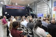 Members of the CBRN Defense community sit down during a presentation to celebrate the Analytical Laboratory System - Modification Work Order's achievement of full operational capacity